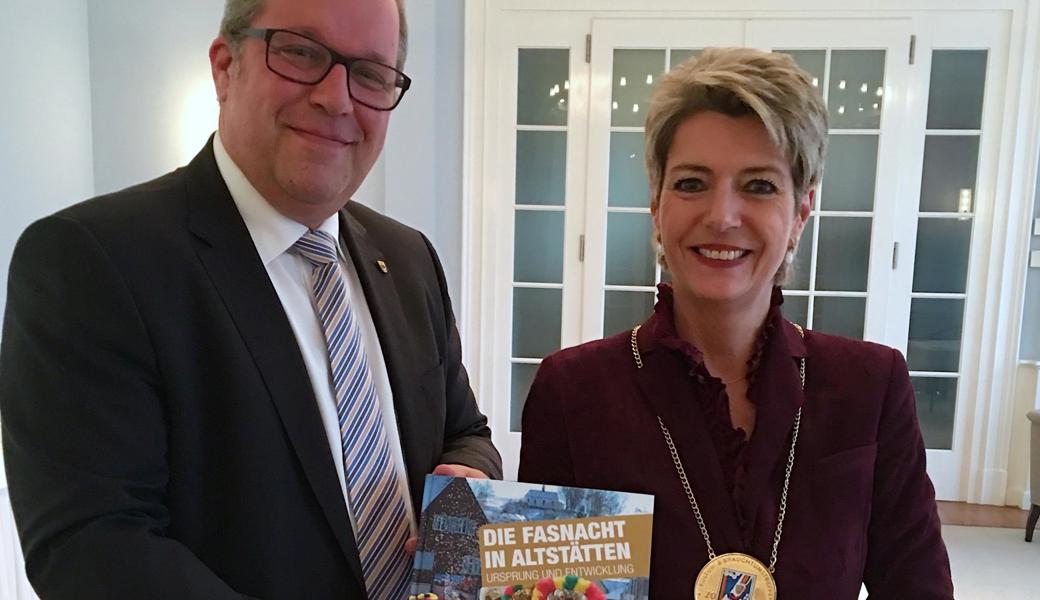 Stadtpräsident Ruedi Mattle überreicht Bundesrätin Karin Keller-Sutter das Jubiläumsbuch zur Altstätter Fasnacht.