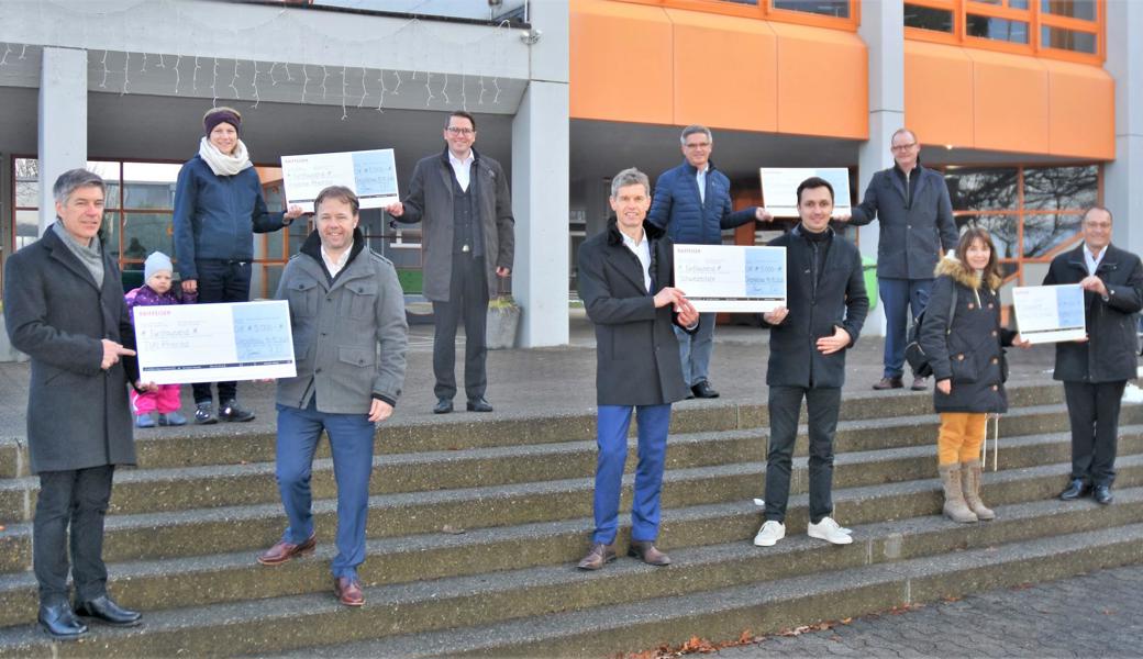 Fünffache Checkübergabe vor dem OZ Kleewies in Diepoldsau (von links): Peter Langenegger (TixiTaxi) und Patrick Windler (Raiffeisenbank Marbach-Rebstein), Franziska Joller-Hutter (Insieme Rheintal) und Andreas Schmid (Filialleiter Diepoldsau-Schmitter), Norbert Lüchinger (Oberes und Rheintal) und Murjan Knöpfler (Schweizertafel), Patrick Benz (Rhyboot) und Thomas Haas (Mittelrheintal) sowie Silvia Meile (A-Treff, E-Treff, Egg-Punkt) und Oswald Wetli (Unteres Rheintal). 