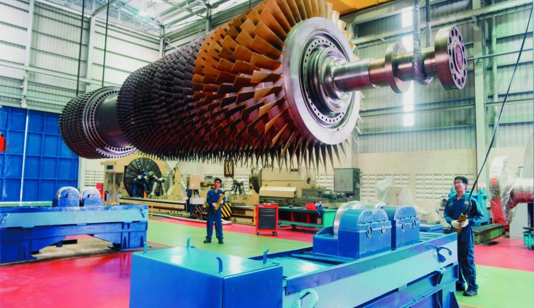 Das Bild zeigt den Rotor einer grossen Gasturbine in Reparatur. Die Gasturbine kommt in einem Kombikraftwerk zum Einsatz.