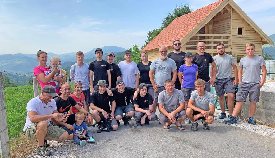 Lehrlinge und Betreuer der Plaston AG, Bauarbeiter und Hausbesitzer posieren vor dem fertiggestellten Haus. 