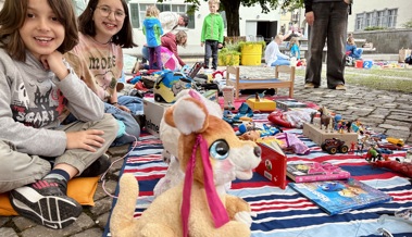 Kinder feilschen im Museumsgarten um aussortierte Spielsachen