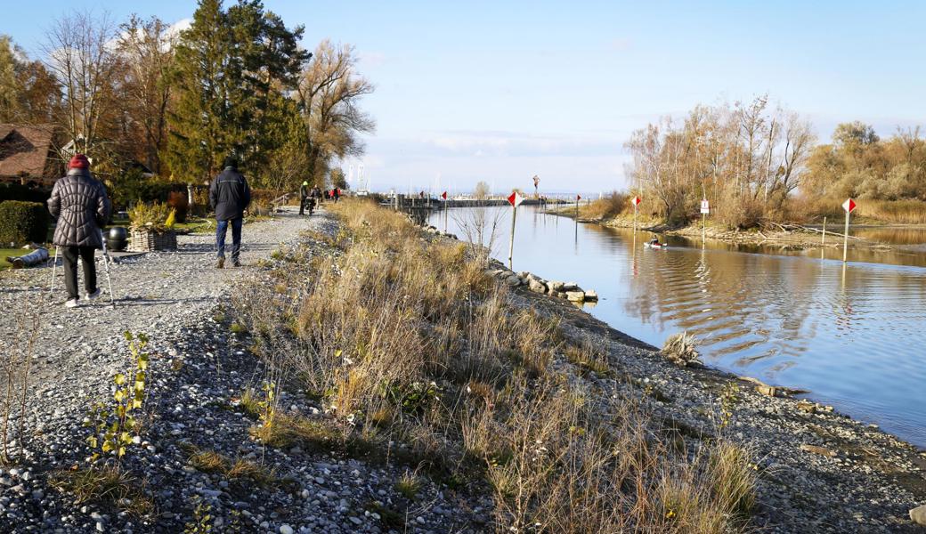 Bei schönem Wetter sind zahlreiche Passanten auf dem Damm unterwegs.