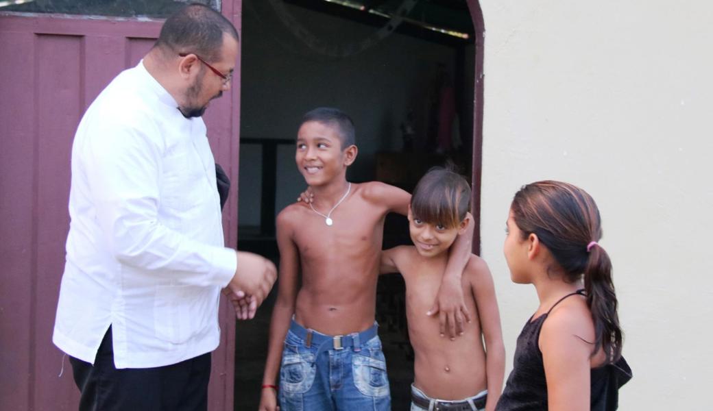 Padre Angel mit Kindern vor der Kapelle in Guarataro in Venezuela.