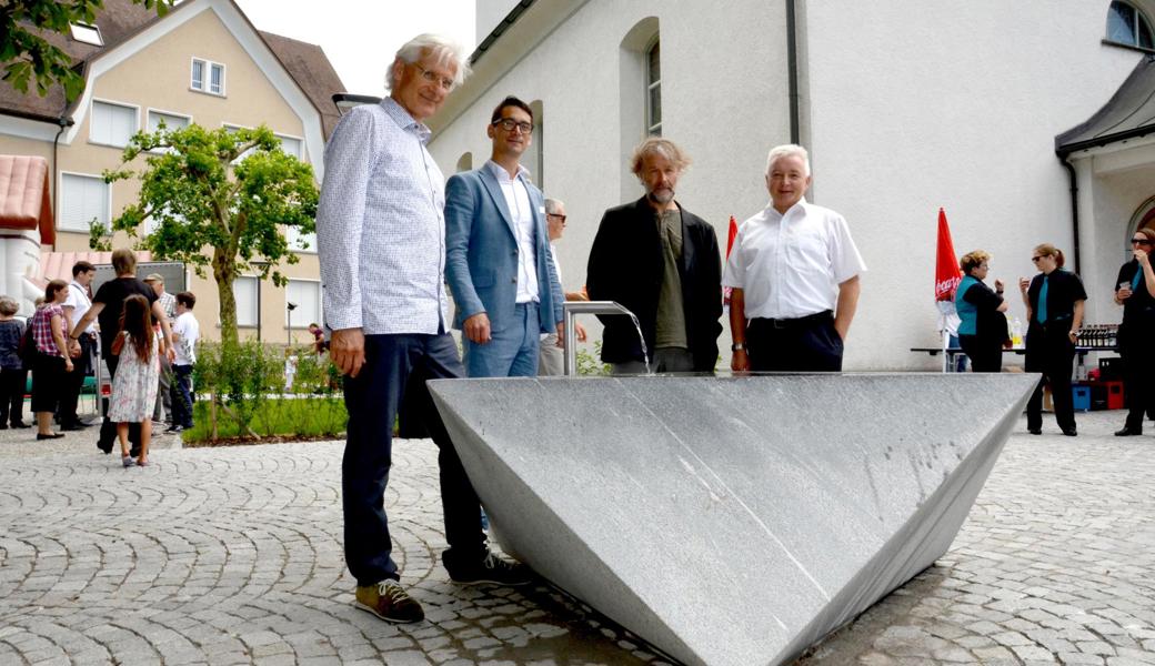 Der Brunnen, der dem Kirchplatz ein Gesicht gibt: (v. r.) Gemeindepräsident Roland Wälter, Architekt und Gestalter Heinz Müller, Patrick Weder und Thomas Widmer, Vizepräsident und Präsident der evangelischen Kirchgemeinde