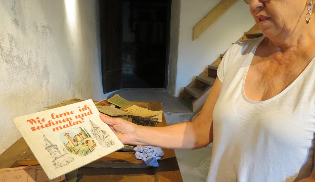 Evelyne Giger mit einem alten Schulbuch.