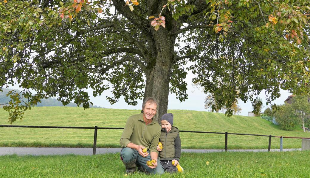 Thomas Heierli und Mauro, der ihm an diesem Tag bei der Obsternte half, unter einem Knoll-Birnenbaum.