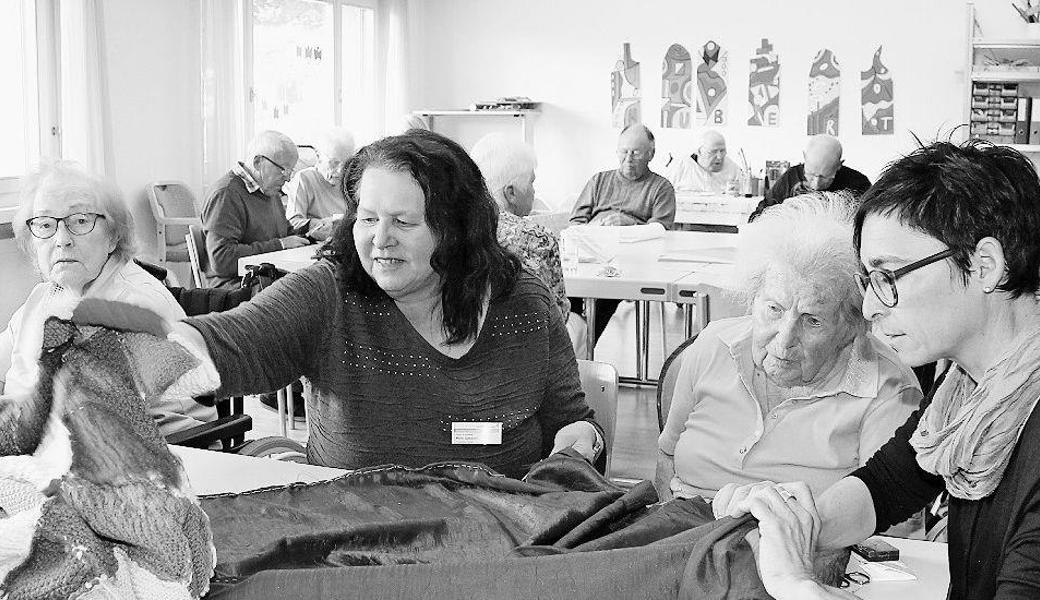 Heidi Gassner (Mitte) ist ehrenamtliche Helferin im Zentrum Augiessen und unterstützt die Fachfrau Corinna Künzler (rechts) beim Handwerken mit den Bewohnerinnen und Bewohnern. Bild: pd