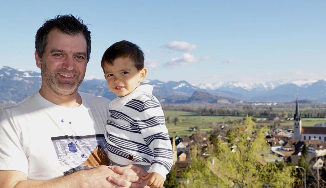 Daniel Graf mit seinem Sohn Nolan auf der Terrasse, wo er den Ausblick ins Tal und auf die Berge jeweils geniesst.