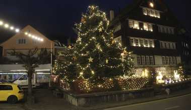 Die Tanne ragt wie in einem Märchenland über die Lichterketten am Dorfplatzrand