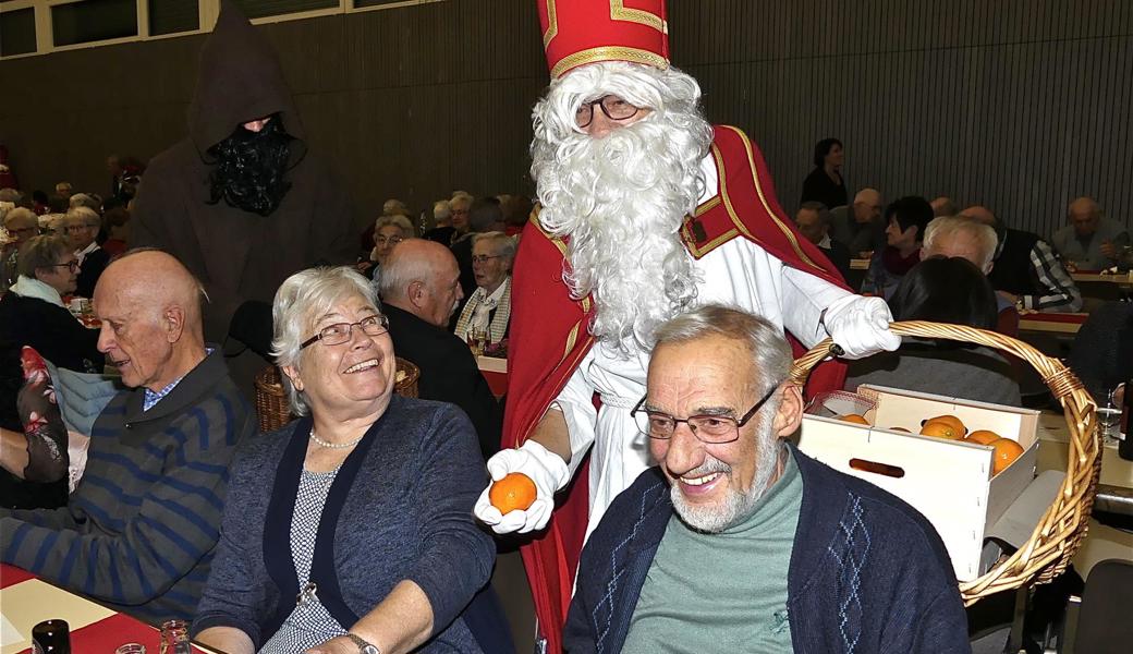 Margret und Hans Hofstetter werden vom Samichlaus und seinem Schmutzli mit Mandarinen und Erdnüssen beschenkt.