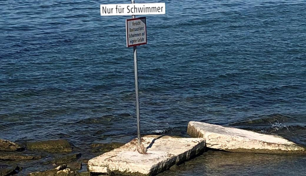 Wegen des tiefen Seepegels ragt das "Nur-für-Schwimmer"-Schild bei der Badi Hörnlibuck komplett aus dem Wasser.