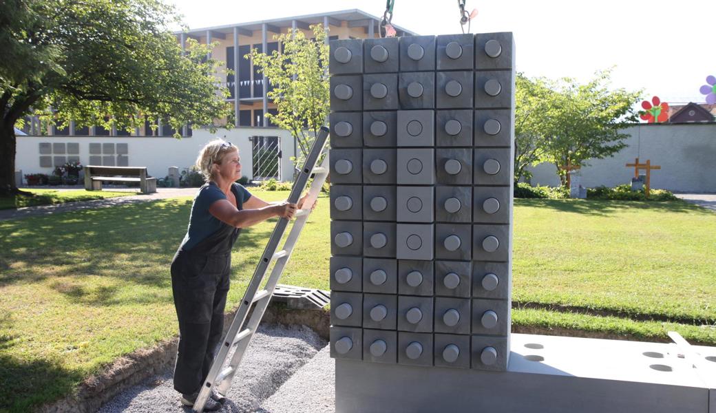 Die St. Galler Bildhauerin Ingrid Tekenbroek bei der Installation des neuen Sandstein-Monolithen.