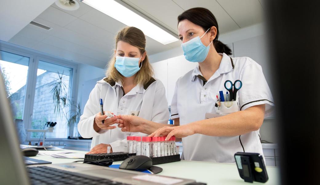 Zwei Laborfachfrauen untersuchen Coronatests.