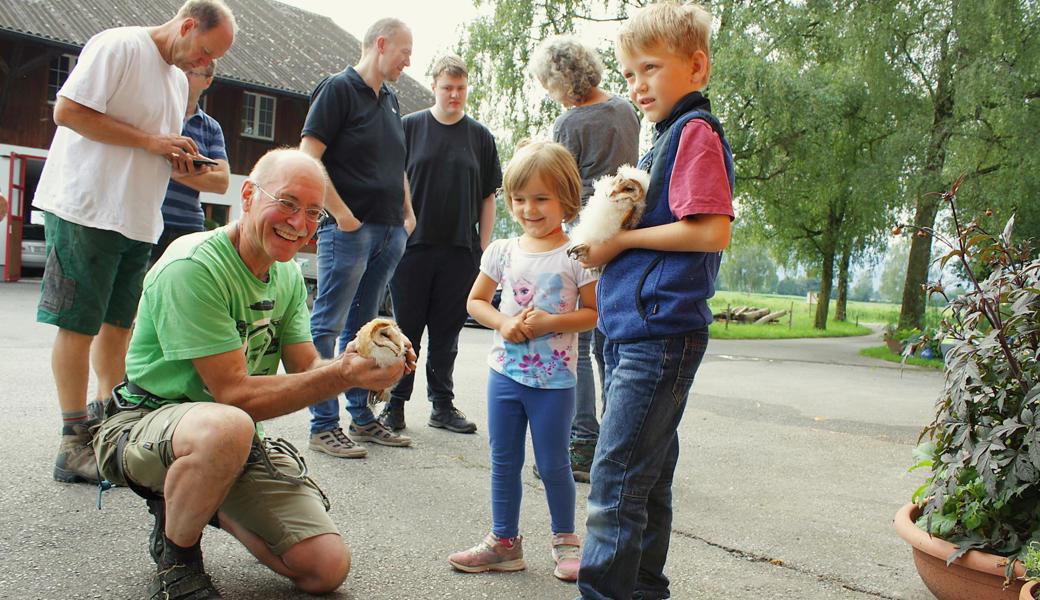 Guido Gschwend und die Kinder präsentieren zwei der fünf Schleiereulennestlinge. 