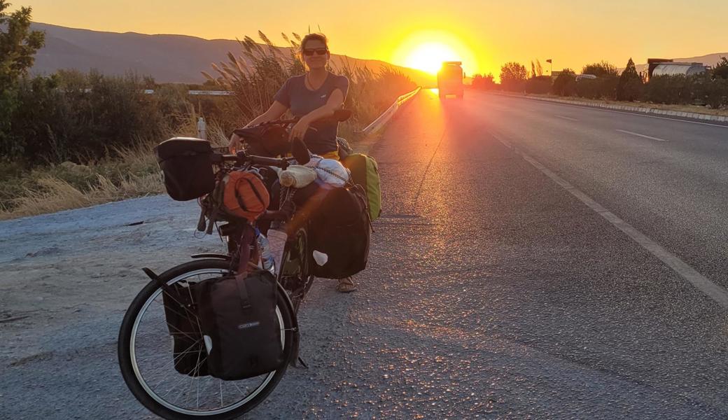 Heidi Naschberger auf ihrem Bike im Sonnenuntergang. Die Reise ist herausfordernd und vielseitig.