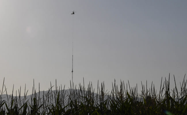 Helikopter baut am frühen Morgen den Windmessmast von SFS ab