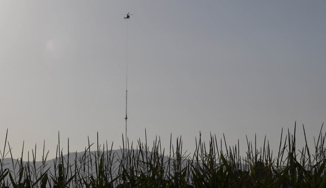 Helikopter baut am frühen Morgen den Windmessmast von SFS ab