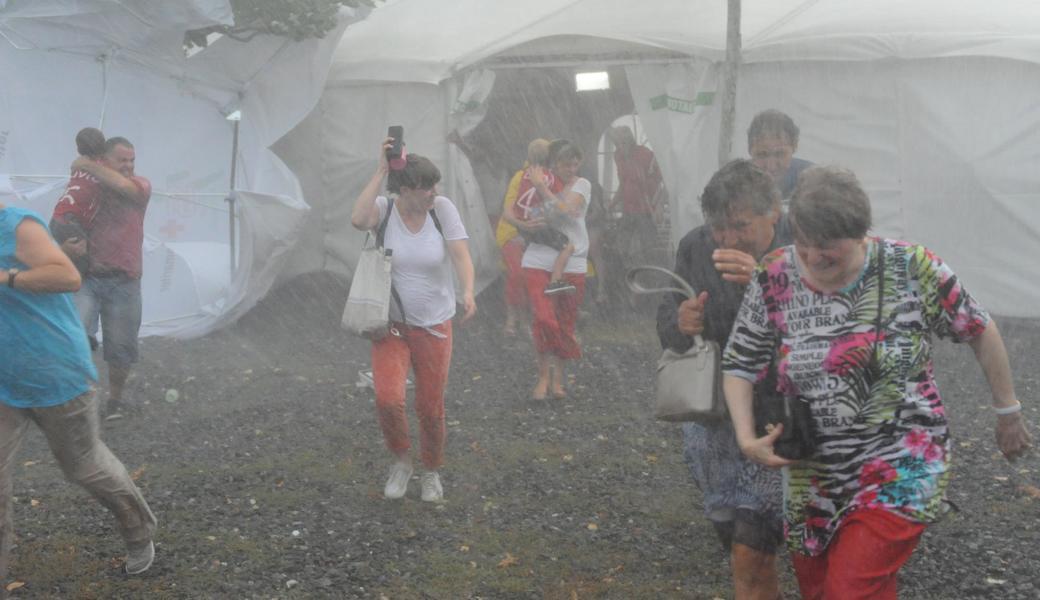 Schnell raus aus dem Festzelt: Als sich trotz eingerammter Sturmanker erste Pfosten zu heben begannen, evakuierten die Organisatoren das Festzelt.