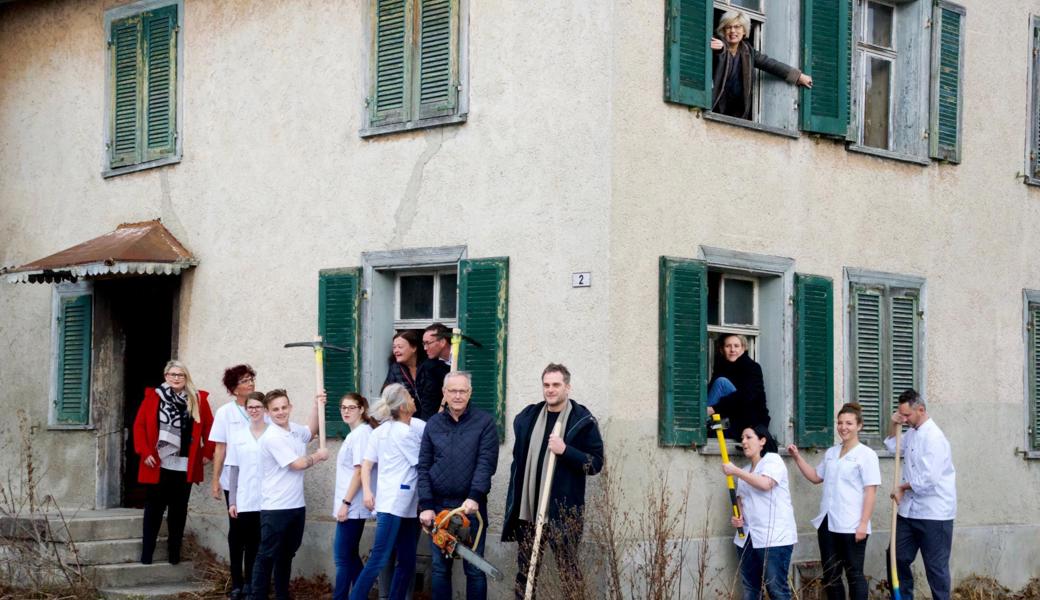 Während die Mitarbeitenden des Alterszentrums Augiessen der Abbruchliegenschaft aktiv zu Leibe rücken, warten die planenden Architekten Bernhard Eberle und Andreas Cukrowicz (Mitte) auf ihren Einsatz. Judith Spirig und Karl Köppel von der Ortsgemeinde Widnau, Gemeinderätin Yvette Werner und Gemeindepräsidentin Christa Köppel verfolgen das Geschehen aus dem Fenster.