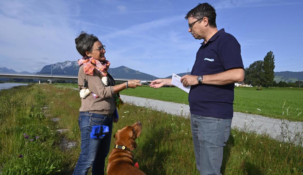 Claudio Senn vom Rheinunternehmen dankt Esther Baumgartner-Jakober und ihrem Labrador Pepe für das freiwillige Abfallzusammenlesen entlang des Rheindamms.