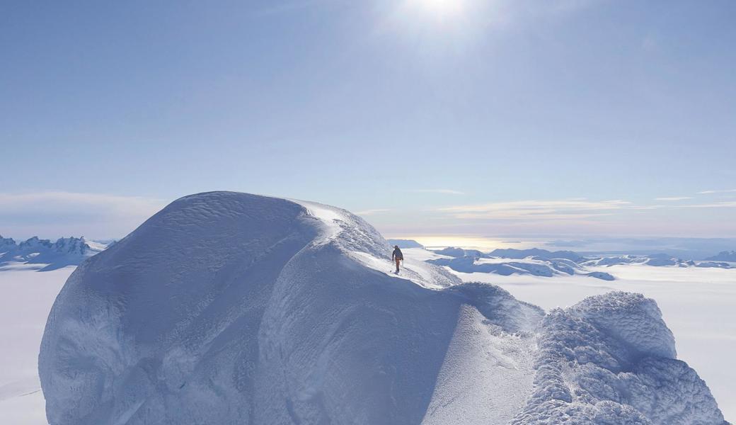 Lukas Hinterberger erreicht den Gipfel des Cerro Largo: Rundherum Eis und Schnee und am Horizont der in der Sonne golden schimmernde Pazifik.