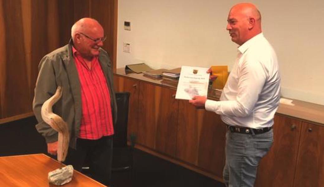 Gemeindepräsident Rolf Huber (rechts) ehrte Martin Nauer senior für sein ehrenamtliches Engagement. Er bekam auch die «Rheinseele» (auf dem Tisch) geschenkt.