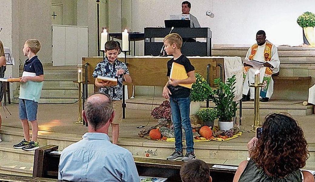 Die neuen Erstkommunionkinder bekommen eine Bibel überreicht. Bild: pd