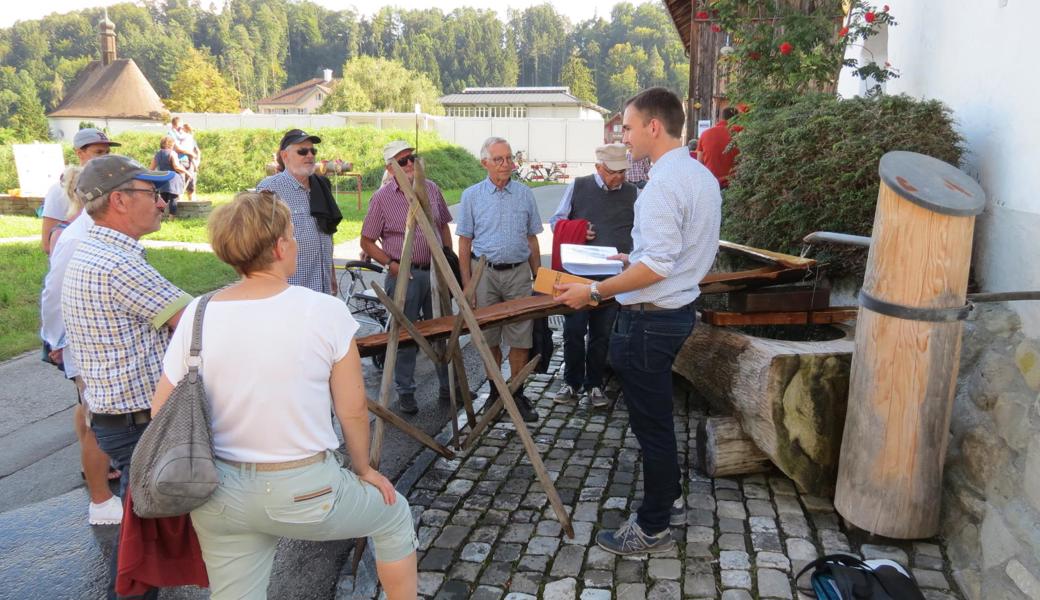 Pascal Zeller  (rechts)zeigt einer Gruppe den Museumsbrunnen