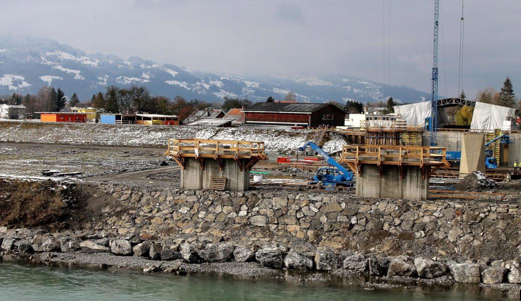 Auf Fussacher Seite sind bereits die ersten Pfeiler betoniert. Im Hintergrund das «Schweisszelt», in dem die Segmente entstehen, die über den Fluss geschoben werden.