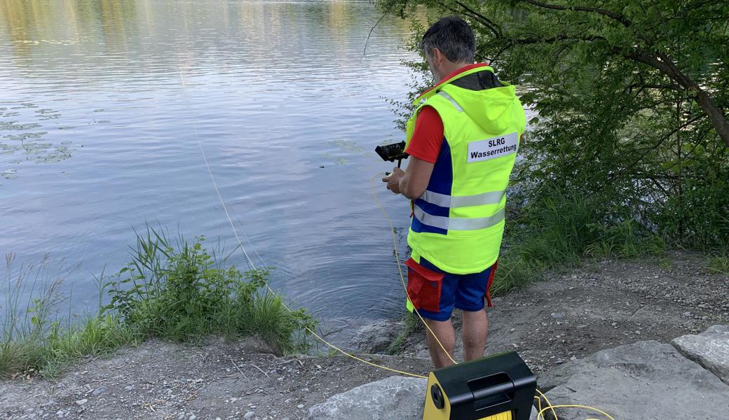 Ein SLRG -asserretter steuert die Unterwasserdrohne vom Ufer aus.