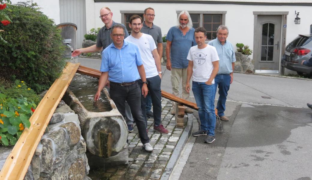 Am Brunnen vor dem Ortsmuseum zeigen die Ausstellungsmacher (v. l.) Peter Jüstrich, Urs Castellazzi, Pascal Zeller, Martin Keller, Rainer Sieber, Pascal Hutter und Erich Gubelmann alte Wasserleitungen. 