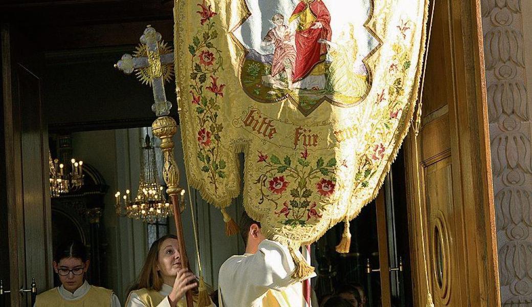 Mit der Fahne des Kirchenpatrons zogen Pfarrer Roman Karrer sowie die Ministrantinnen und Ministranten in die Kirche ein. 