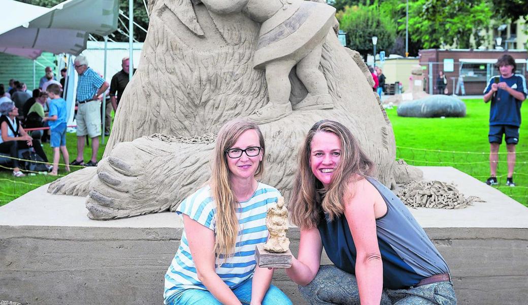 Ein Mädchen geht einem Eisbären ans Fell: Die Siegerinnen des 21. Sandskulpturenfestivals, Charlotte Koster und Eeva Karhu, posieren vor ihrer Skulptur.