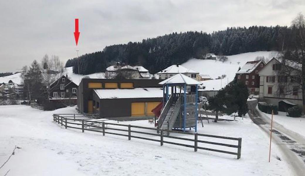 Der rote Pfeil zeigt auf das Visier, das die neue Swisscom-Mobilfunkantenne anzeigt. Im Vordergrund befindet sich ein Spielplatz.