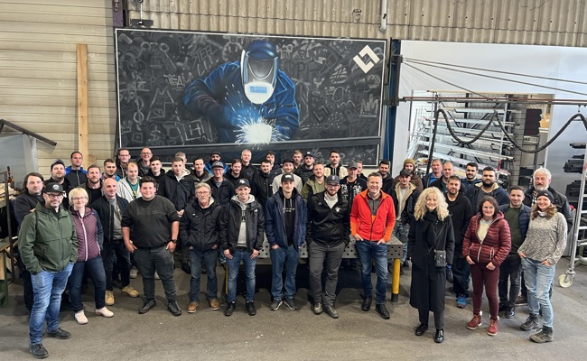 Mitarbeitende gestalten ein Teambild als Graffiti