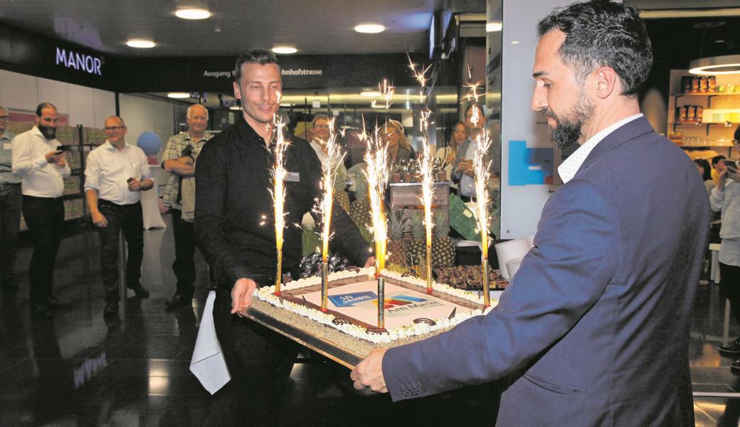 Store-Manager Heerbrugg Italo Tempini (rechts) und Manora-Gerant Remo Hug bringen die Geburtstagstorte.