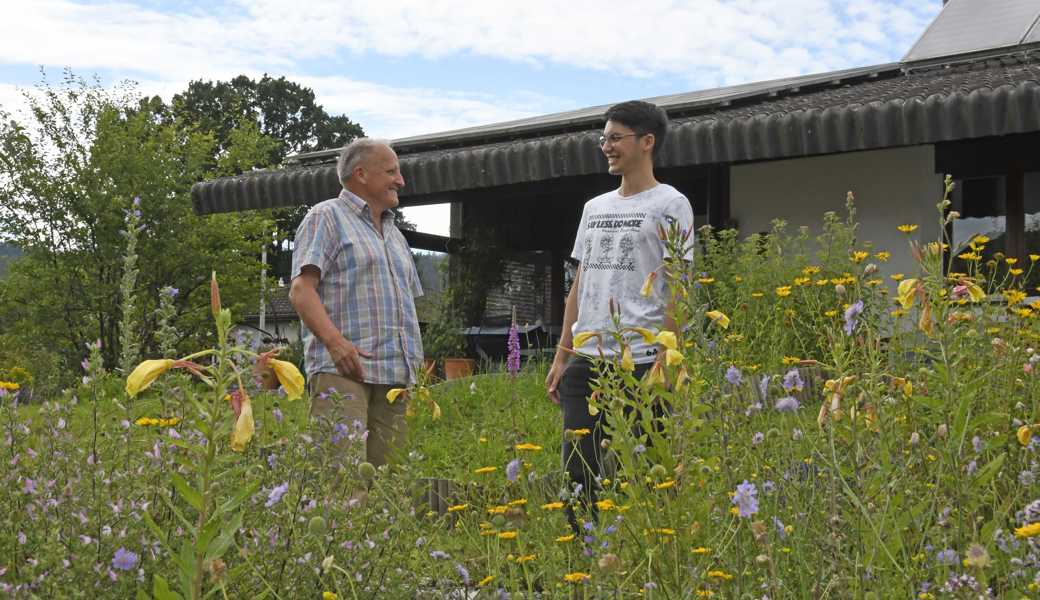 Peter Riedener (links) und Philipp Oesch haben den Garten des Pensionierten für das Foto ausgewählt. Die Blumenwiese sehen sie sinnbildlich für eine blühende Zukunft der Schulkinder. Ihre Berufung war und ist, den Grundstock hierfür zu legen. 