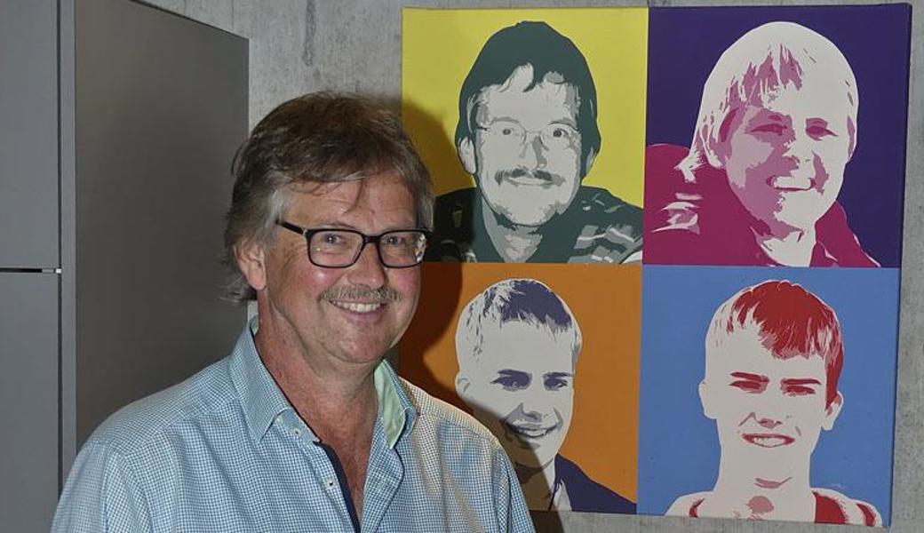 Jan Esser posiert zu Hause vor dem Portrait seiner Familie.