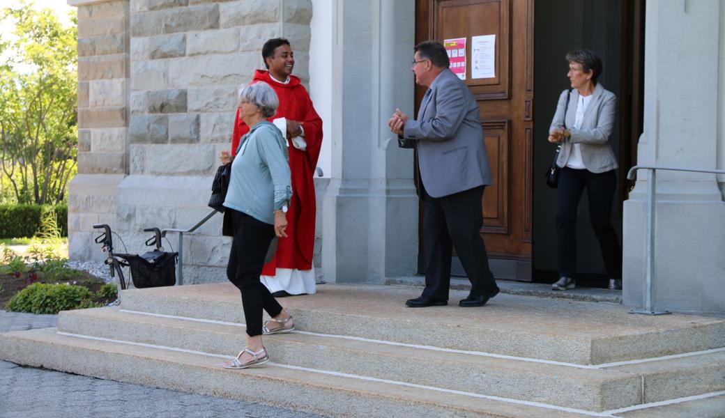 Kaplan Georg Changeth verabschiedete die Kirchgänger, die sich beim Verlassen der Kirche Desinfektionsmittel in die Hände gerieben haben. 