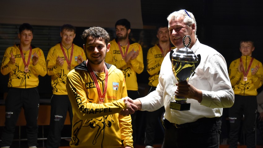 Michel Steger nimmt den Pokal für den dritten Platz entgegen.