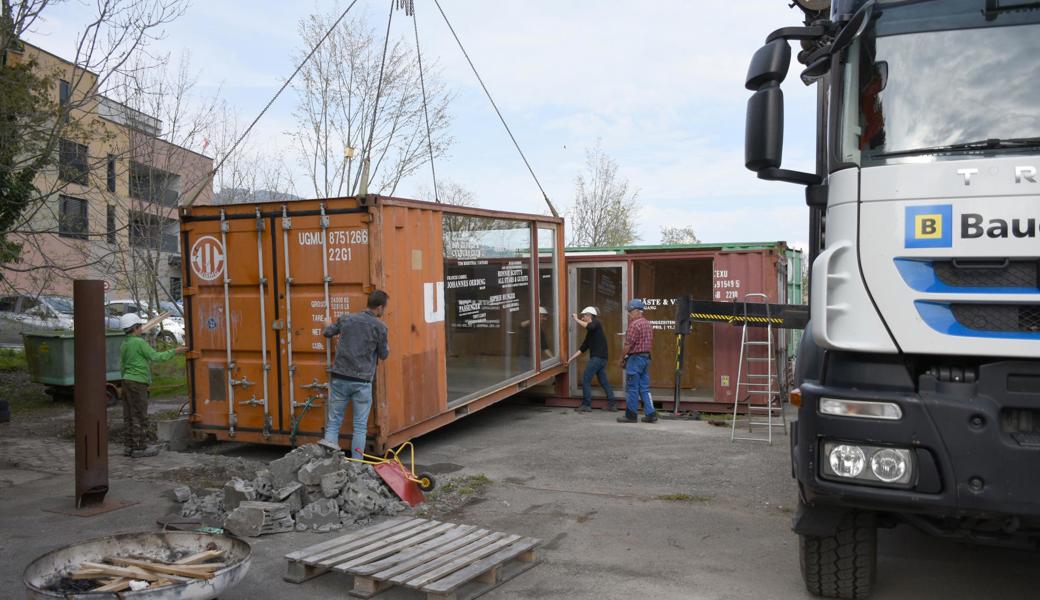 Während einige Leute mit dem Aufbau des Schulgartens beschäftigt sind, verfolgen andere Mitglieder des Vereins Zwischennutzung Gärtnerei das Abladen und Platzieren der Container, die kürzlich noch in Zermatt standen.