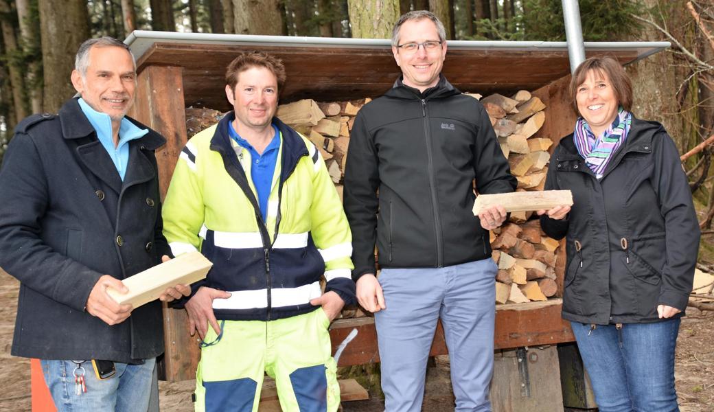 Gemeindepräsident Michael Litscher (3.v.l.) freut sich über das Brennholz für die Feuerstelle.