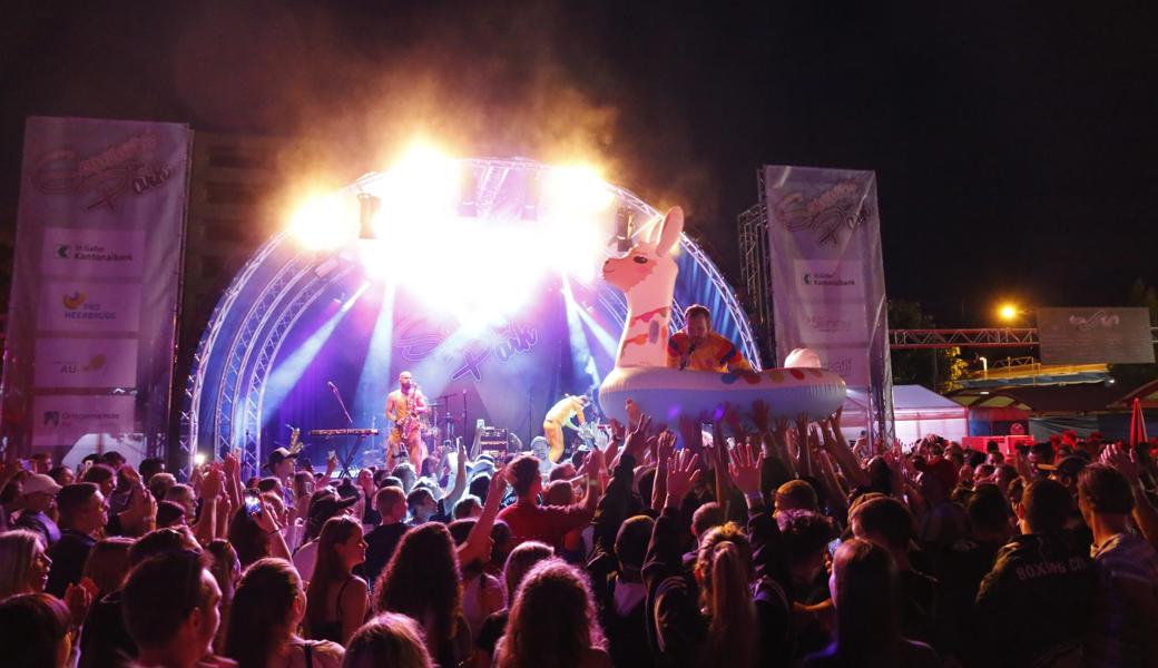 Wenn der Sänger der Band "Les Touristes" im aufgeblasenen Lama Crowdsurfing macht...