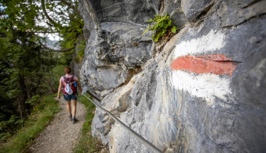 Weiss-rot-weisse Symbole markieren Bergwanderwege. Auf ihnen kann Absturzgefahr bestehen.