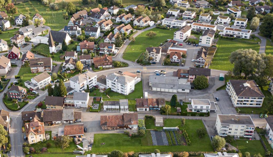 Oberhalb der Dorfstrasse (im Bild unten) entstehen Wohnhäuser und ein Begegnungsplatz: Die bestehenden drei Gebäude oberhalb der Dorfstrasse müssen der Neugestaltung weichen.